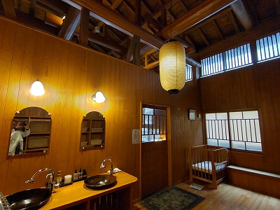 旅館多郎兵衛の大浴場「薬師の湯（男）」の前室。大きな提灯の照明や窓ガラスがノスタルジックな印象を与える